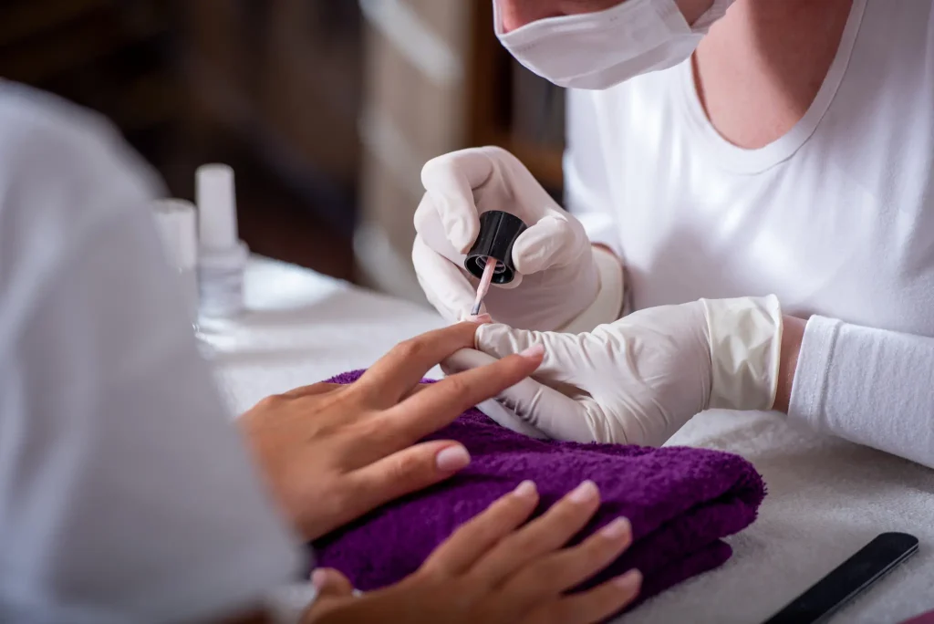 hands-beautician-polishing-woman-nails-110483980